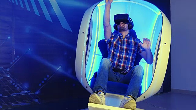 年轻人沉浸在虚拟现实的经验，坐在一个移动的椅子视频下载