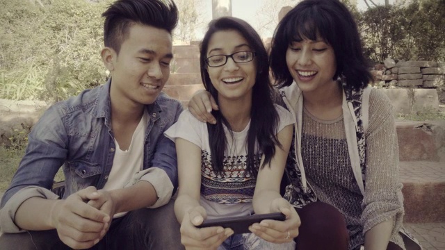 多民族快乐，大学朋友一起分享智能手机。视频下载