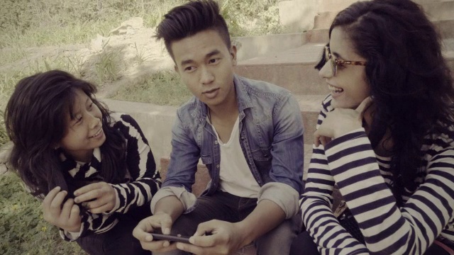 多民族快乐，大学朋友一起分享智能手机。视频素材
