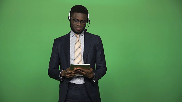 非洲男性支持呼叫中心平板电脑和耳机视频素材