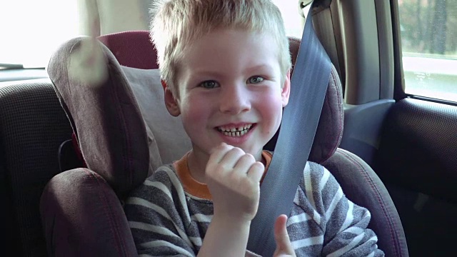 可爱的男孩在儿童座椅微笑和大笑视频素材