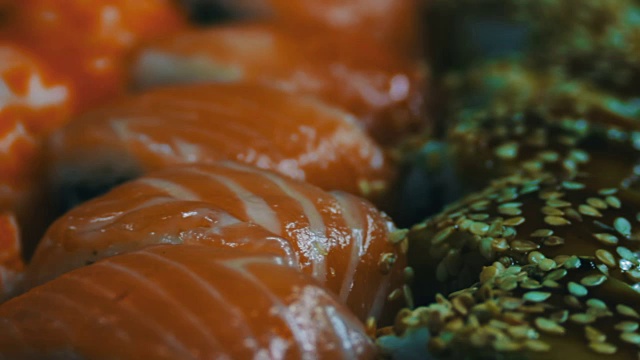用新鲜生鱼做的日本寿司。一种日本菜，由米饭、鲑鱼或金枪鱼、虾和浸在酱油中的鱼卵制成视频素材