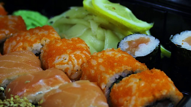 新鲜的日本寿司和卷，宏生鱼片，浦卷和夜拍。典型的日本菜视频素材