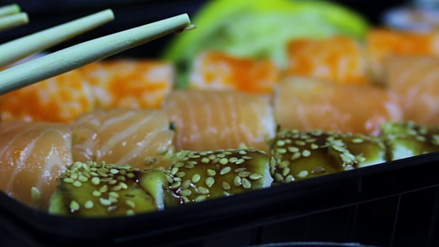 新鲜的日本寿司和卷，宏生鱼片，浦卷和夜拍。典型的日本菜视频素材