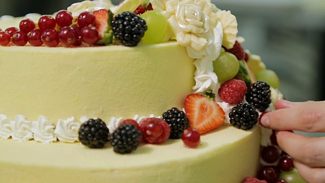 蛋糕制作的过程。糕点师用浆果装饰蛋糕视频下载