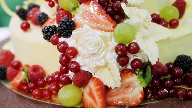 蛋糕上装饰有红醋栗、葡萄、草莓、黑莓、覆盆子和奶油视频下载