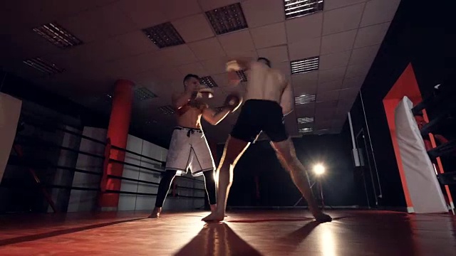 拳击手正用四肢击打教练。MMA的培训视频下载