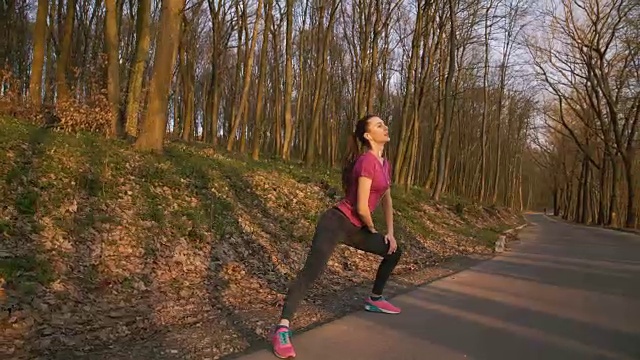 这个女孩在公园的自然环境中做伸展运动视频下载