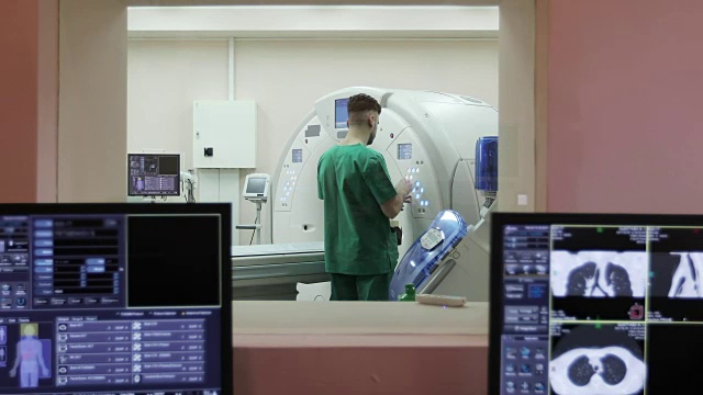 在一家新的现代癌症治疗医院的CT扫描室旁边有一间装有电脑和监视器的扫描室。视频素材