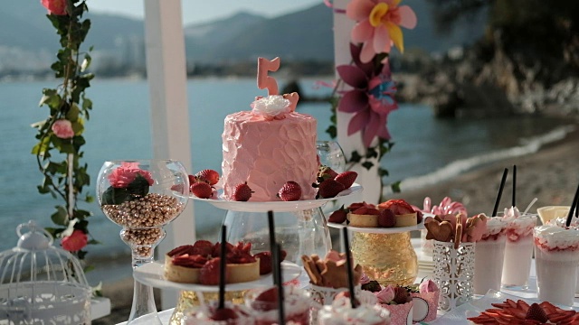 蛋糕，甜品和鲜花组合在桌子上的海上视频下载