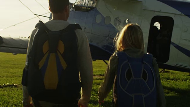 带着降落伞的男人和女孩向飞机移动视频下载
