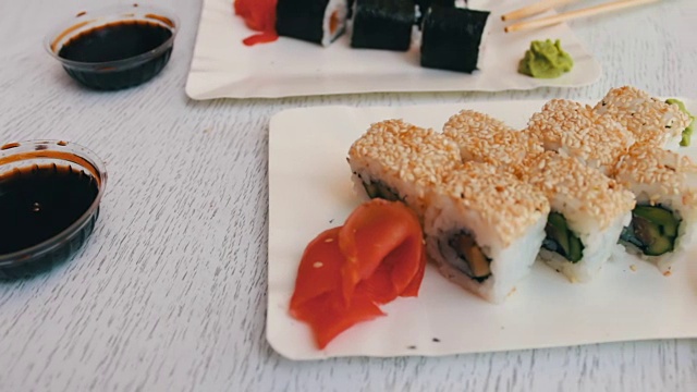 日式寿司:在白色盘子里放上鲑鱼、生姜、青芥末和酱油视频素材