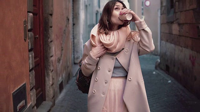 年轻美丽的时尚女人的肖像行走在城市。女孩早上去上班，喝咖啡视频素材