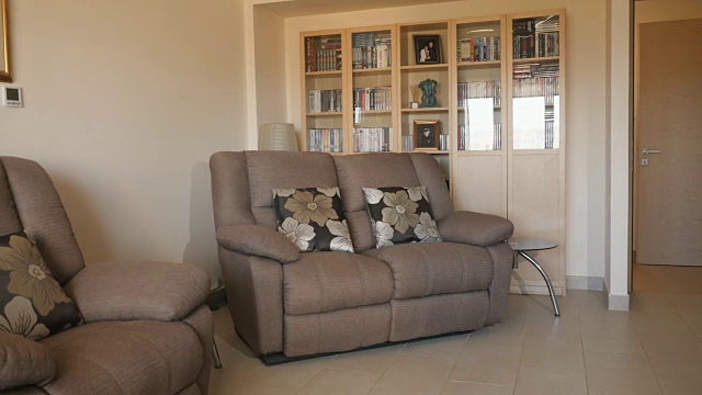 现代设计的客厅配有沙发和书柜视频素材