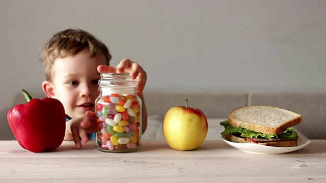 可爱的小男孩和一罐彩色糖果视频素材
