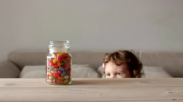 可爱的小女孩拿着一罐彩色糖果视频素材