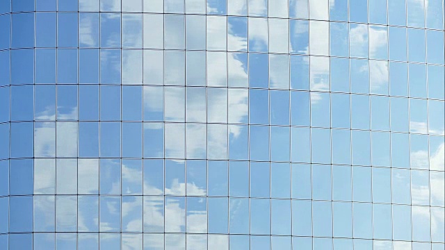云朵映在现代办公大楼的窗户上视频下载