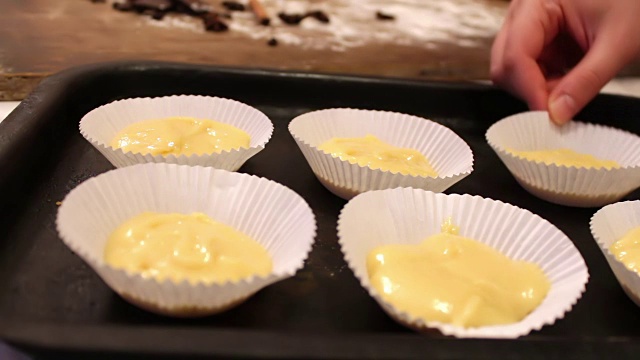 松饼的生面团，撒上巧克力块，放在特制的纸烤盘里视频素材