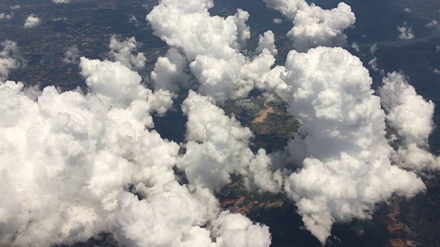 飞机飞过云层和陆地的鸟瞰图视频素材