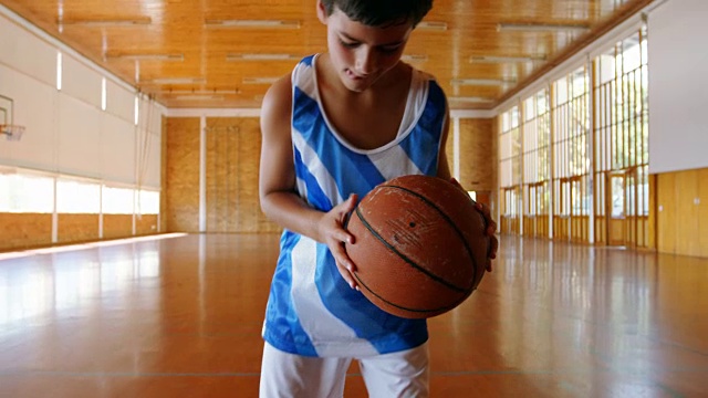 一个男生在篮球场上拿着篮球的肖像视频下载