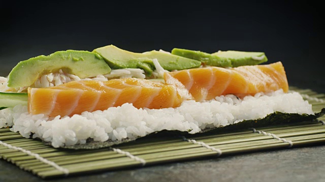 专业厨师准备寿司卷与三文鱼和鳄梨在日本餐厅视频下载