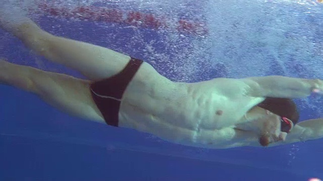 专业游泳运动员在水下做一个转身，用脚推墙。视频下载