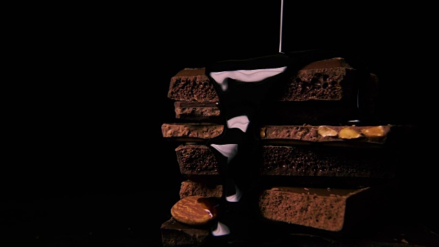 将液态黑巧克力倒在一堆巧克力上视频素材