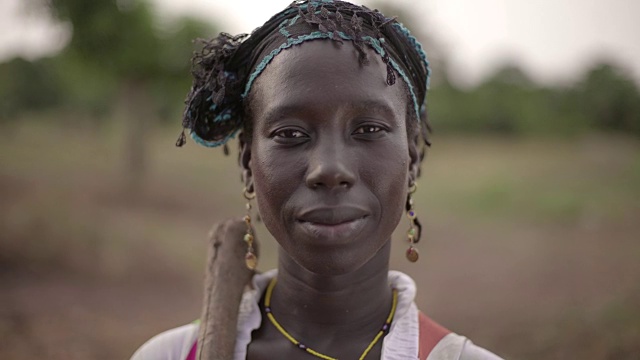 一个年轻的非洲女农民对着镜头情不自禁地笑视频素材