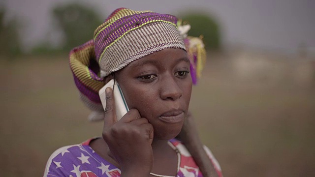 这是一幅年轻的非洲女农民用手机自发交谈的照片视频素材