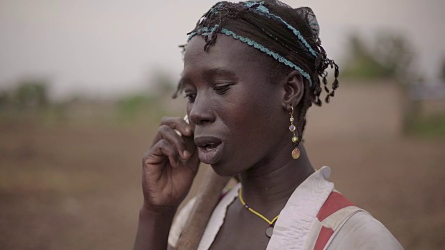 这是一幅年轻的非洲女农民用手机自发交谈的照片视频素材