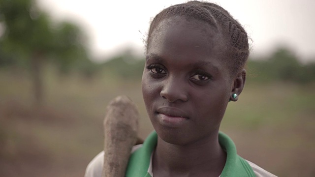 一个年轻的非洲女农民对着镜头情不自禁地笑视频素材