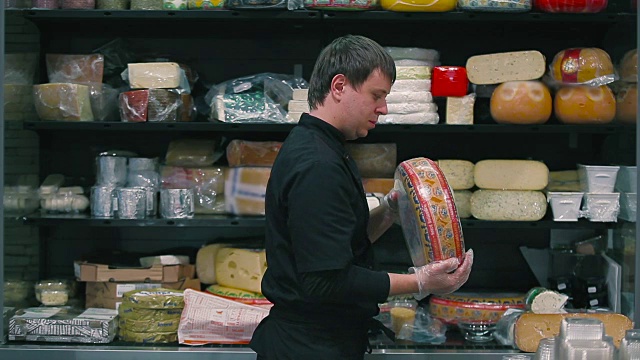 超市里的卖主正在挑选奶酪视频下载