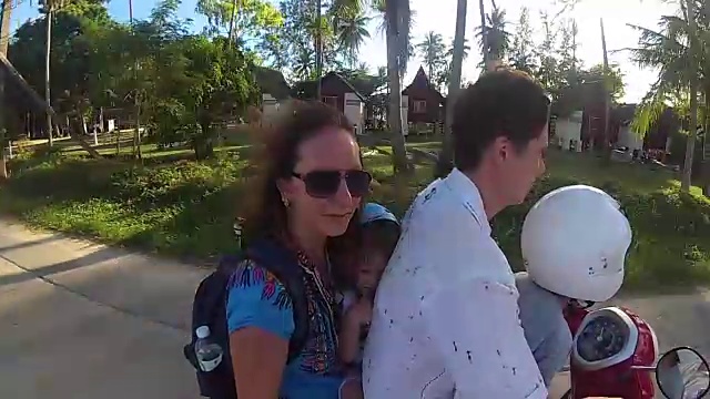 一个快乐的家庭在热带骑摩托车。一个阳光明媚的日子。帕,泰国视频下载