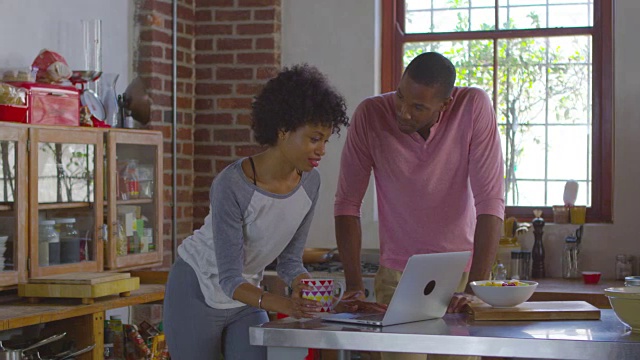 一对黑人夫妇在厨房用电脑喝咖啡，用R3D拍摄视频素材