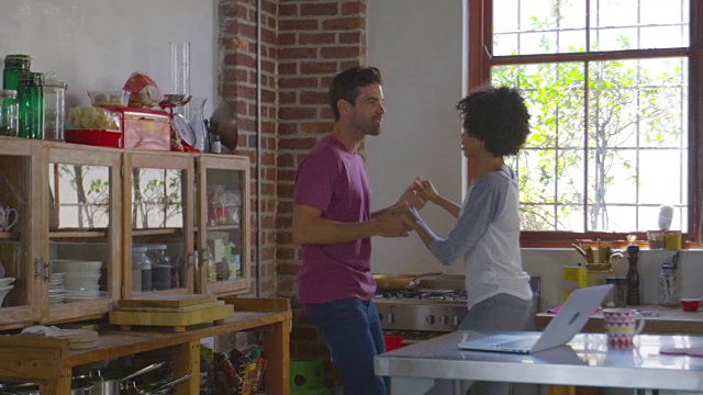 年轻的混血夫妇在厨房跳舞，用R3D拍摄视频素材