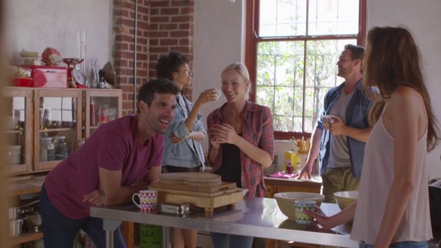五个朋友在厨房边喝咖啡边笑，用R3D拍摄视频素材