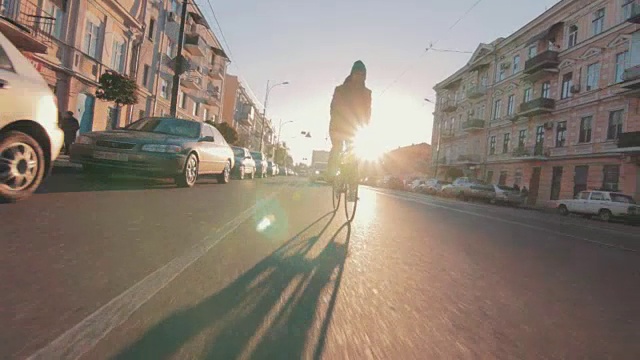 骑自行车的人骑固定齿轮运动自行车在阳光明媚的一天在一个城市日落视频素材