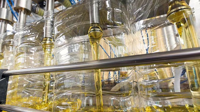 工厂生产设备灌装葵花籽油的瓶子。4 k。视频下载