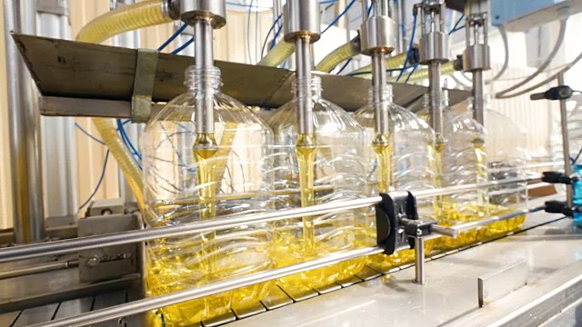 一条全自动液体洗涤剂生产线。工作中装瓶的机器。4 k。视频下载