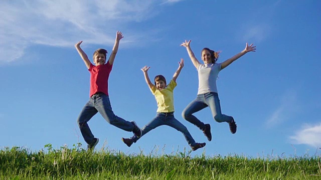 快乐的一家人在碧绿的草山上跳跃，映衬着蓝天视频素材
