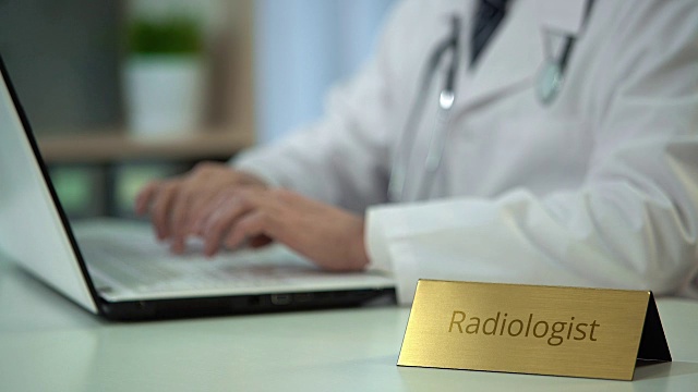 放射科医生在诊所用笔记本电脑输入报告，保存医疗记录视频下载
