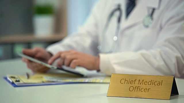 首席医疗官在检查平板电脑和医疗应用的临床记录视频素材
