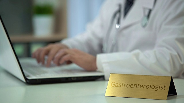 胃肠科医生在笔记本电脑上输入医疗报告，提供在线咨询服务视频素材