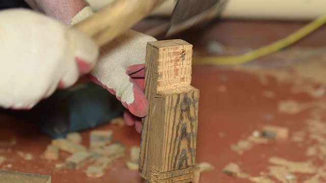 木匠在室内用斧头把木板劈开视频下载