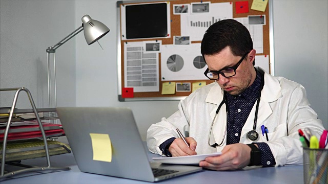 在工作场所使用笔记本和医疗表格的医生。视频素材