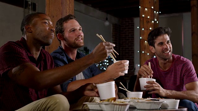 三个男性朋友边吃中餐边看电视，拍摄于R3D视频素材