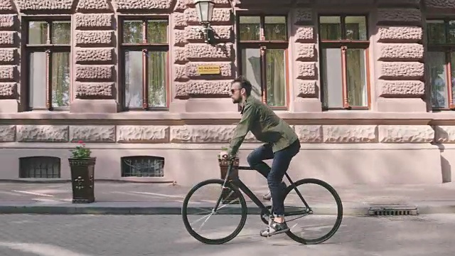 骑自行车的人骑固定齿轮运动自行车在阳光明媚的一天在一个城市视频下载