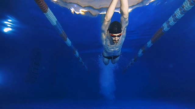 水下风景到美丽的专业游泳运动员跳水到游泳池和游泳超过镜头。视频素材