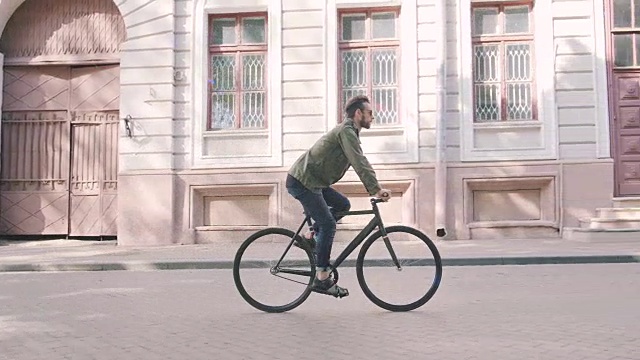 骑自行车的人骑固定齿轮运动自行车在阳光明媚的一天在一个城市视频素材