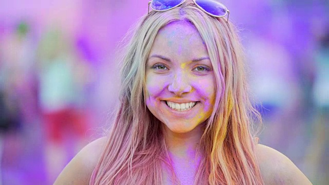 快乐的年轻女士兴奋的脸对着镜头微笑，在胡里节玩得很开心视频下载